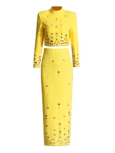 Elegant yellow two-piece set featuring a beaded cropped top and high-waist maxi skirt