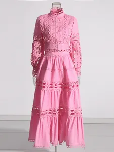 Elegant pink hollow out lace two-piece set featuring a cropped top and long tiered skirt