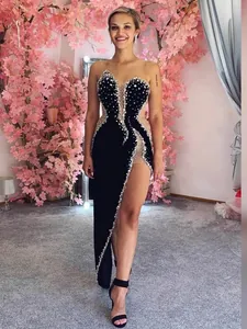 Elegant black velvet evening gown with luxury beadwork and a sexy high slit detail.