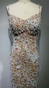 Detailed view of luxury beadwork and sequin embroidery on white feather evening gown