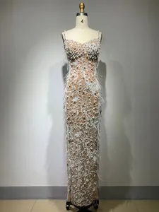 Detailed view showing white sequin embroidery and feather trim on a luxury gown