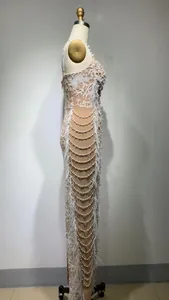 Detailed side view of an elegant white sequin embroidery evening dress with feathers
