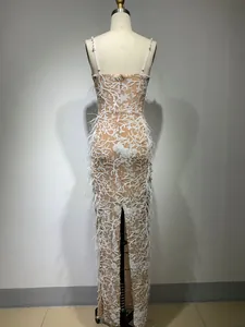 Detailed back view of an elegant nude evening gown with white sequin and feathers