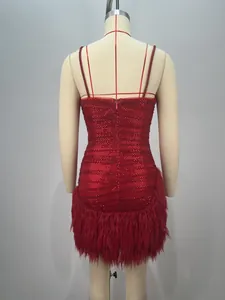 Détail arrière d'une mini robe rouge à paillettes avec fermeture éclair et plumes