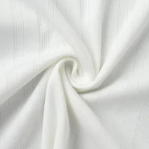 Macro detail of white knitted pointelle fabric with delicate heart jacquard pattern