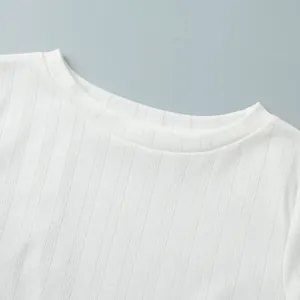 Detail showing white knitted crew neck with elegant heart jacquard pattern texture