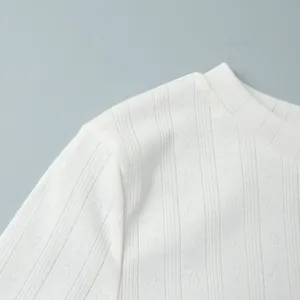 Close-up of white knitted fabric with hollow heart jacquard pattern and ribbed texture