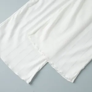 Close-up of white heart jacquard knitted fabric with delicate ribbed texture and ruffled hem