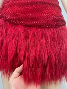 Gros plan sur les paillettes rouges et les plumes douces d'une robe de soirée chic