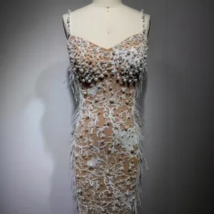 Luxurious white sequined beaded evening gown with feather trim and floral embroidery