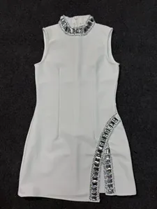 Gedetailleerde weergave van een witte bandagejurk met strass-hals en zijsplit detail