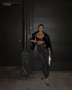 Full-length view of a sparkling rhinestone mesh skirt in a night street setting.