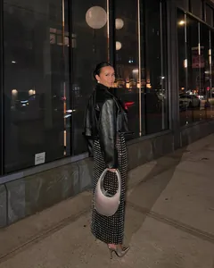 Fashionable full length view of a sparkly rhinestone sheer midi skirt on a model