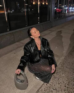 Street style view of sparkling rhinestone sheer midi skirt paired with leather jacket.
