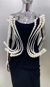 Detailed shot of an elegant black strapless evening gown featuring ornate pearl bead shoulder decor