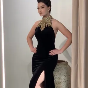 Vestido de noche largo de terciopelo negro con cuello halter, lentejuelas y abertura alta