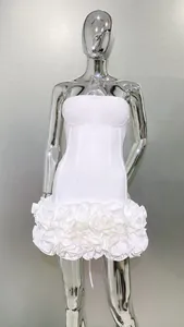Elegant white strapless mini dress with ruffled floral hem on a silver mannequin.
