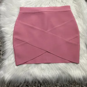 Detail shot of a stylish pink criss-cross bandage mini skirt on white faux fur background