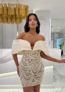 Elegant pearl beaded mini dress detail featuring scalloped embroidery and ruffled off-shoulder top