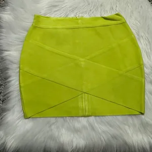 Close-up detail of the unique criss-cross bandage texture on a lime green mini skirt