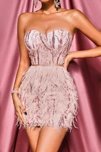 Close-up detail of a pink sequin strapless bandage dress with ostrich feather trim