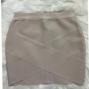 Close-up of beige bandage mini skirt with crisscross strap design and bodycon fit