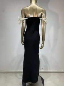 Vista trasera detallada de un vestido de noche negro con adornos de perlas 3D en las mangas