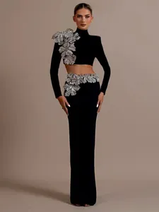Detail of elegant black two-piece set featuring heavy silver floral beadwork and long sleeves.