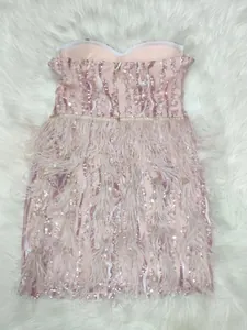 Detail view of pink sequins and delicate feathers on strapless evening dress
