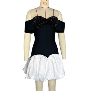 Dettaglio frontale dell'elegante abito nero con paillettes e gonna a bolla bianca satinata