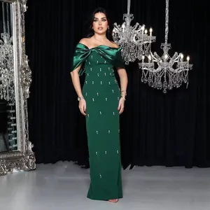 Elegant emerald green off-shoulder evening gown with bow and sparkling rhinestone detail