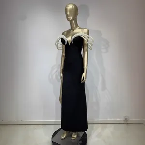Elegante vestido de fiesta negro tipo bandage con detalles de perlas 3D y abertura alta.