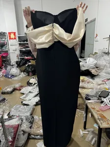 Dettaglio di un elegante abito da sera nero senza spalline con fiocco in raso crema