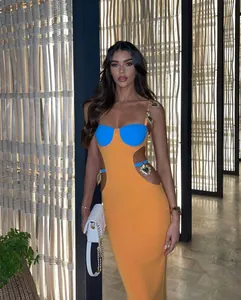 Detailed view of the cut-out waist and gold heart charms on the luxe bandage dress