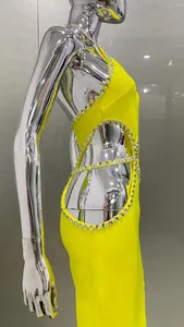Side view of vibrant yellow halter party dress with rhinestone trim and sexy cutouts
