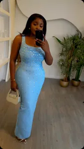 Close-up of sparkling rhinestone embellishments on a light blue bandage maxi dress