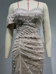 Detailed macro view showing exquisite pearl beading and sequin textures on a champagne gown