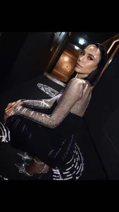 Detail eines schwarzen Bandagekleids mit glitzernden Strass-Netzärmeln für Partys.