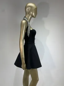Detailed side view of a black halter dress featuring elegant rhinestone beading on collar.