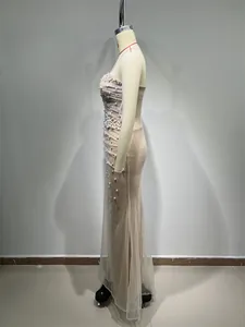 Detailed side view of an elegant champagne mermaid evening gown with pearls and sequins