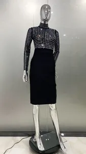 Vue complète de la robe midi noire à manches longues avec motifs de strass carrés brillants