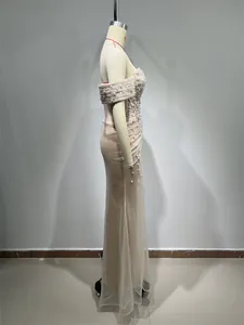 Side view of an elegant champagne beaded evening dress with pearls on a studio mannequin