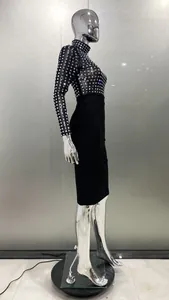 Vue latérale d'une élégante robe bandage noire à manches longues avec strass sur mannequin