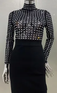 Détail de la robe bandage noire à manches longues avec strass et maille transparente
