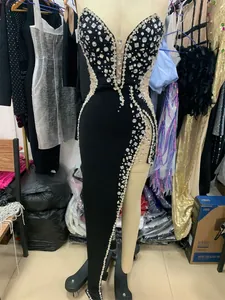 Close-up of luxurious rhinestone beading and high slit on a black evening gown