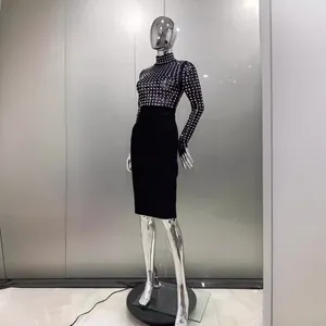Élégante robe bandage noire à col montant avec des détails de strass scintillants.