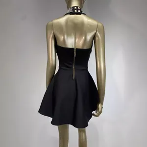 Elegant black halter-neck party dress with beaded collar and open back on mannequin.