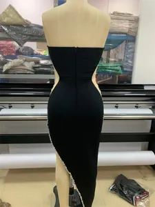 Detailed back view of a luxury black strapless bandage dress with rhinestone slit.