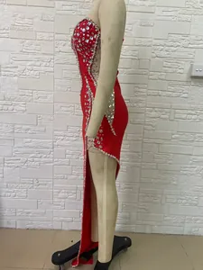 Detailed side view of a red strapless evening dress with luxury rhinestones and side slit