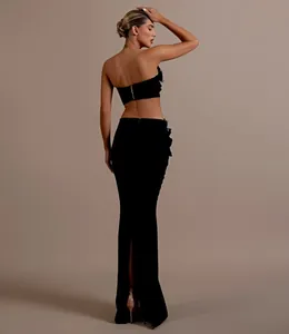 Vista posterior de elegante conjunto de fiesta negro de dos piezas con top de pedrería.